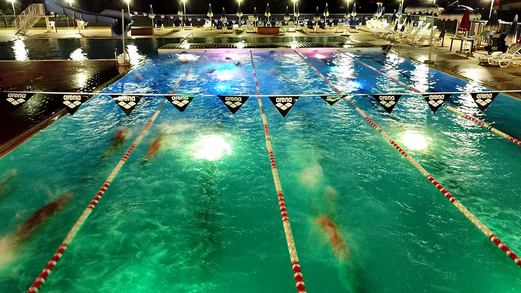 Ragazzi del camp nuoto NESC nuotano in piscina di notte